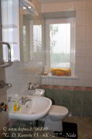 Sanitariniame kambaryje dušo kabina, praustuvė su veidrodžiu ir WC