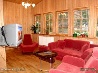 There is modern furniture with sleeping mechanisms in a spacious porch-sitting room.